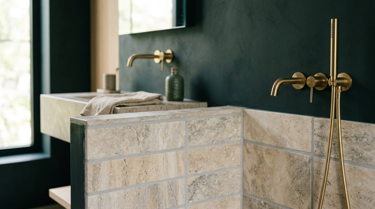 Alkaline grout cleaner and antimicrobial sealer bottles next to a grout brush on bathroom shower tile